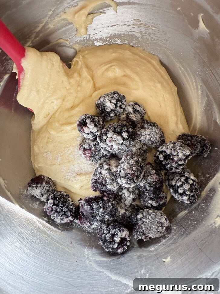 Adding the blackberries to the batter.