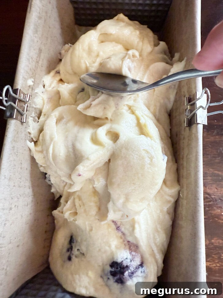 Lemon blackberry batter spooned into the loaf pan.