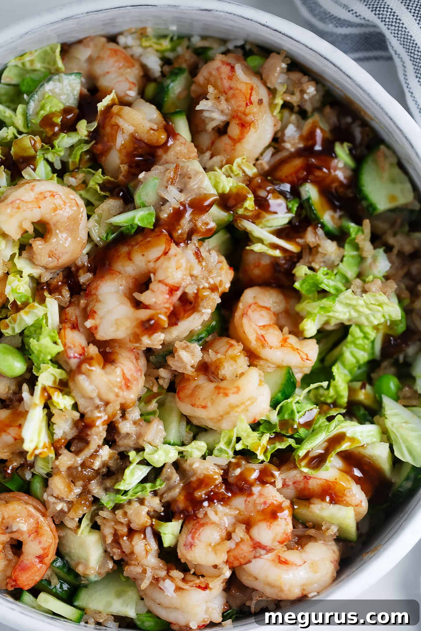 A close-up shot of the finished Teriyaki shrimp and crispy rice salad in a salad bowl, garnished with sesame seeds.