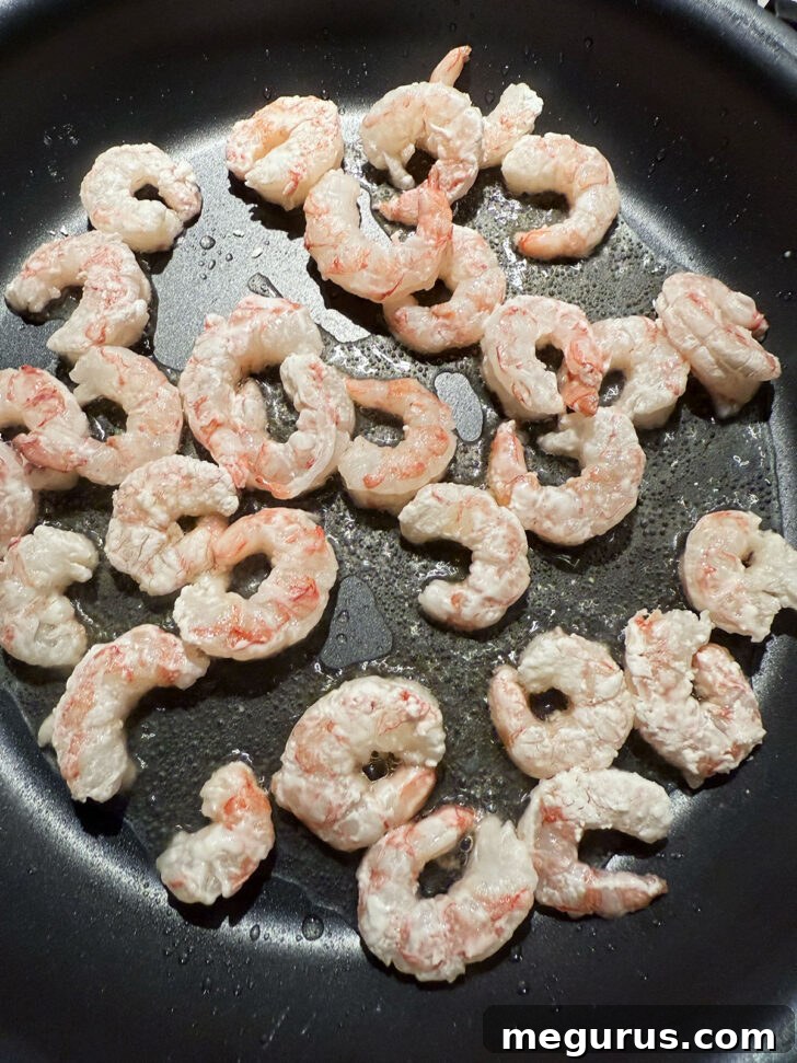 Cooking the shrimp in a hot skillet.