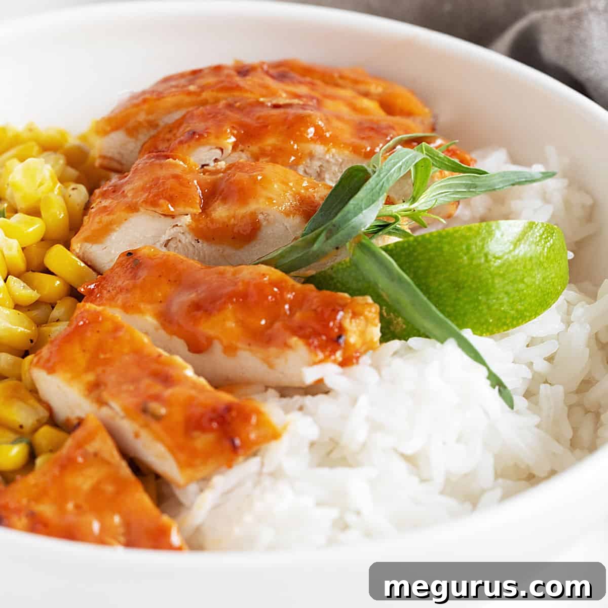 Grilled chicken breasts coated in homemade peach BBQ sauce, served with corn and rice.