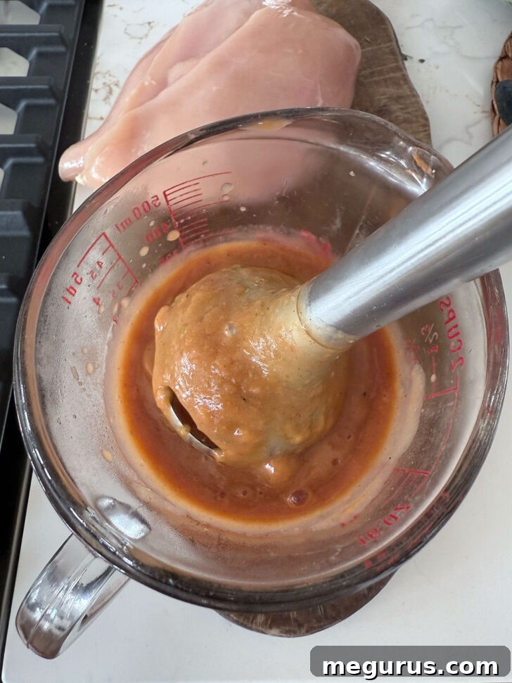 Smoothing the peach BBQ sauce with an immersion blender.
