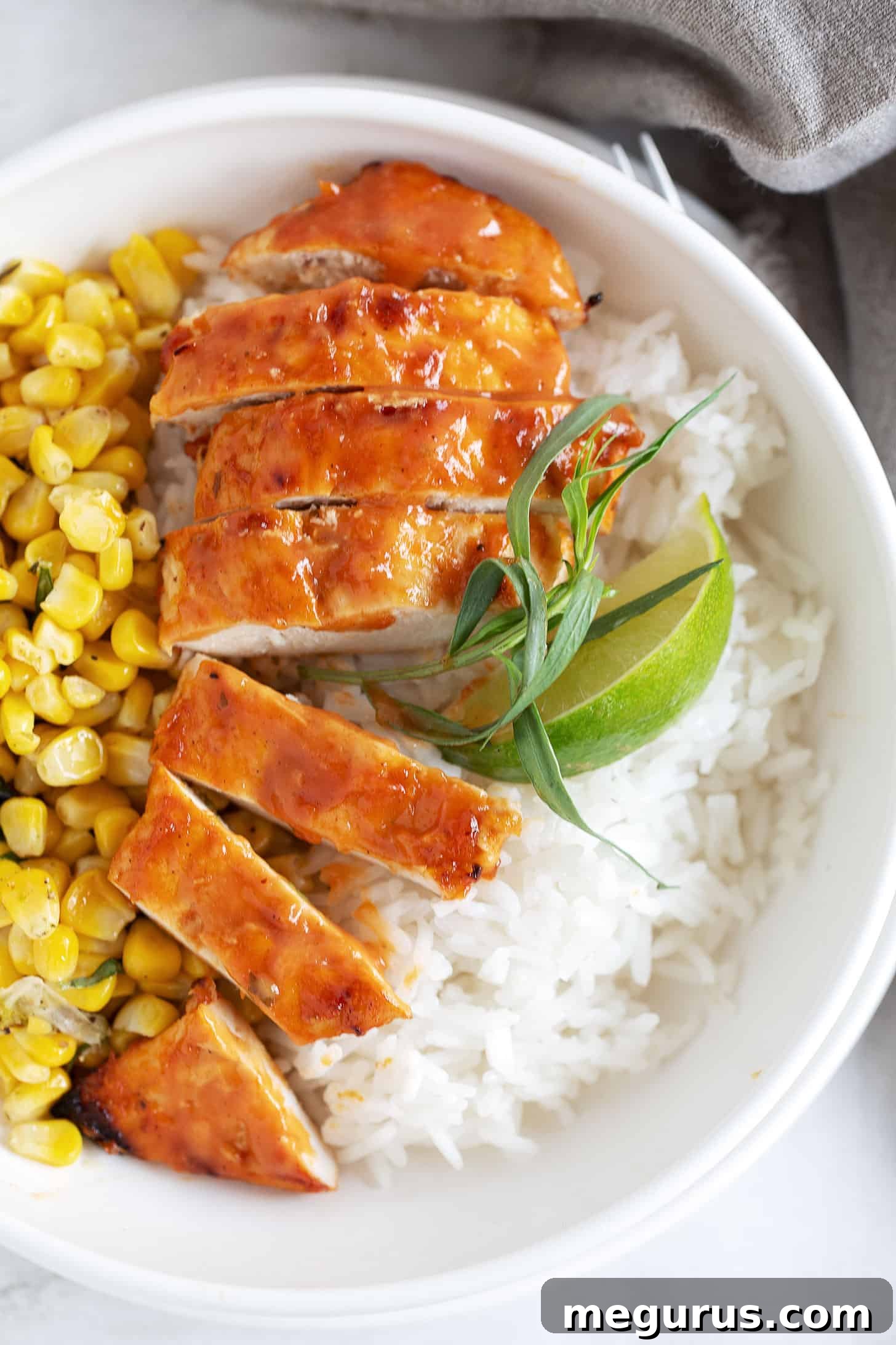 Grilled chicken breasts coated in homemade peach BBQ sauce, served with corn and rice.