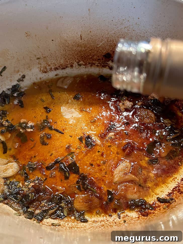 Deglazing the pan with a splash of wine to loosen browned bits after the pork is removed.