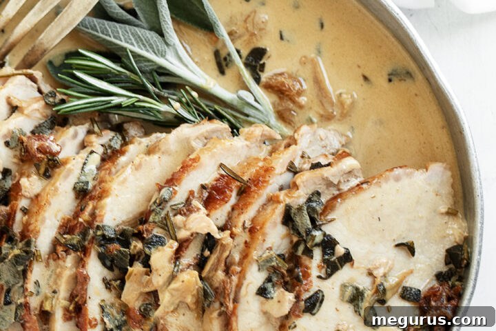 Pork loin with wine herb gravy on platter with fork, beautifully presented.
