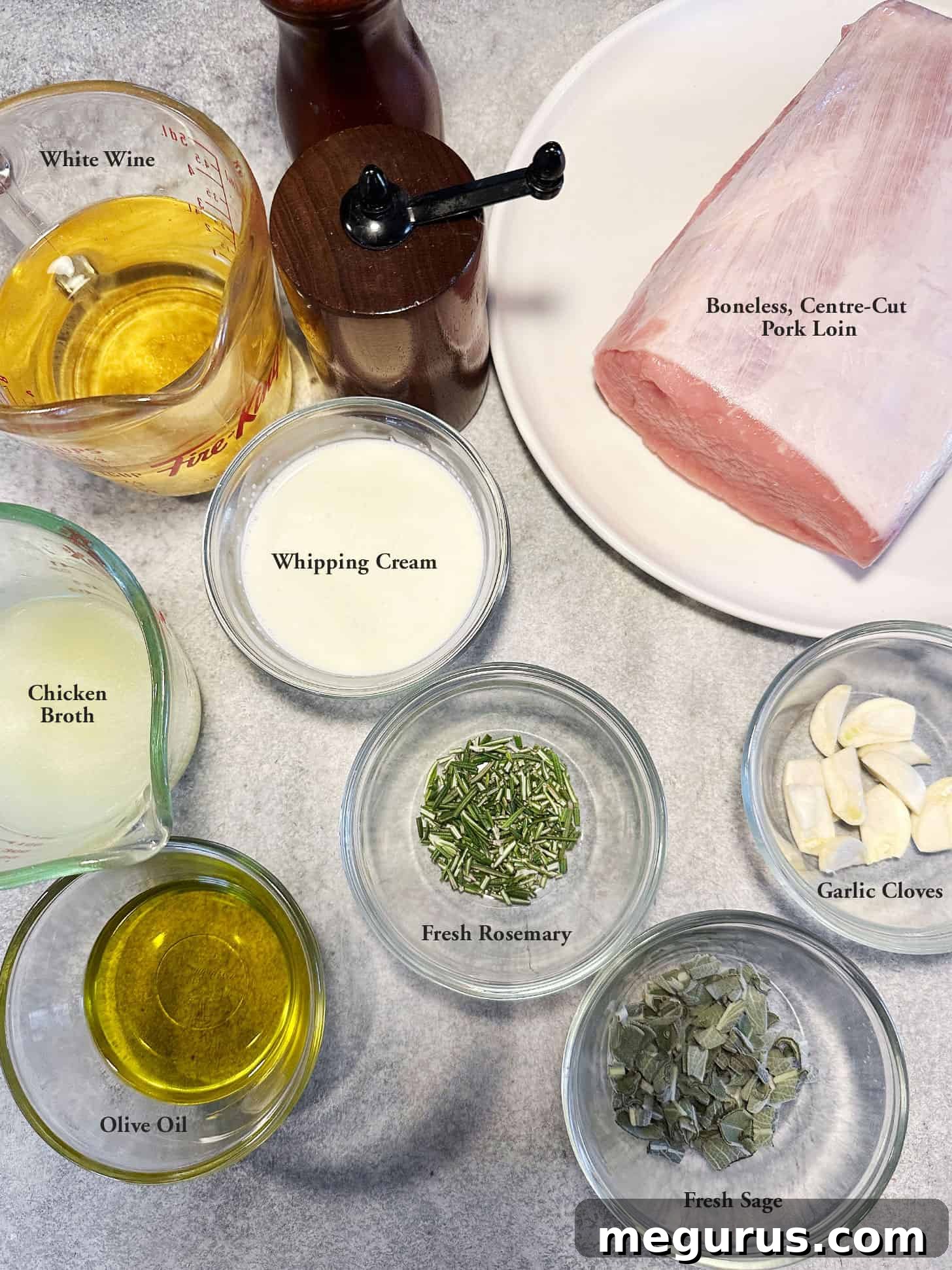 Layout of fresh ingredients for pork loin with wine and herb gravy, including a pork loin roast, white wine, fresh sage, fresh rosemary, garlic, and cream.