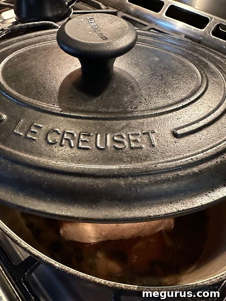 Partially covering the Dutch oven with a lid during the slow stove-top cooking process.