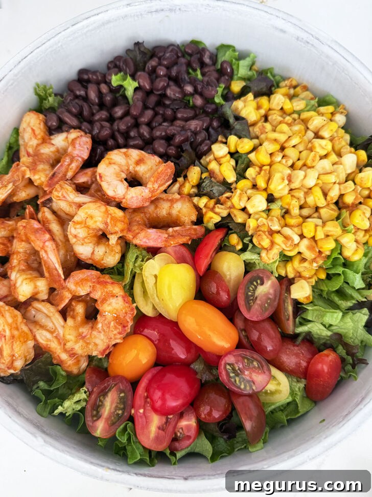 Shrimp, corn, black beans and tomatoes added to the top of the lettuce.