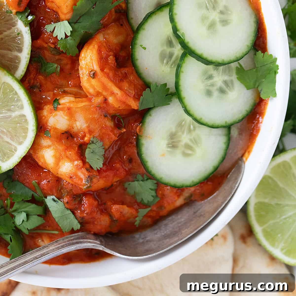 Indian butter shrimp in a white bowl, garnished with fresh cilantro.