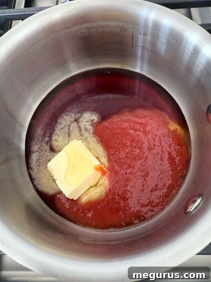 All the honey sriracha sauce ingredients – butter, honey, sriracha, soy sauce, and lime juice – are combined in a small saucepan.