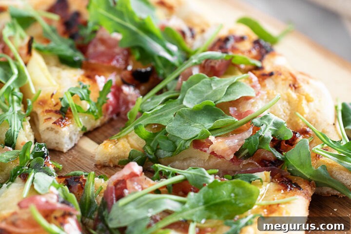 Apple cheddar and pancetta pizza on pizza peel.