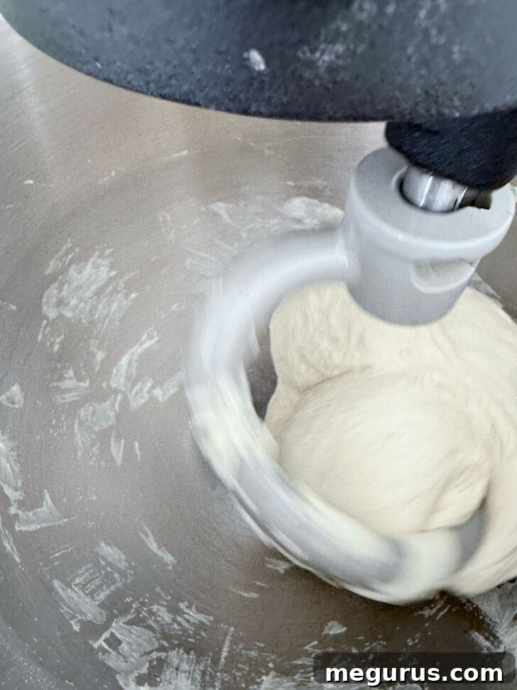 Pizza dough mixing in a stand mixer.