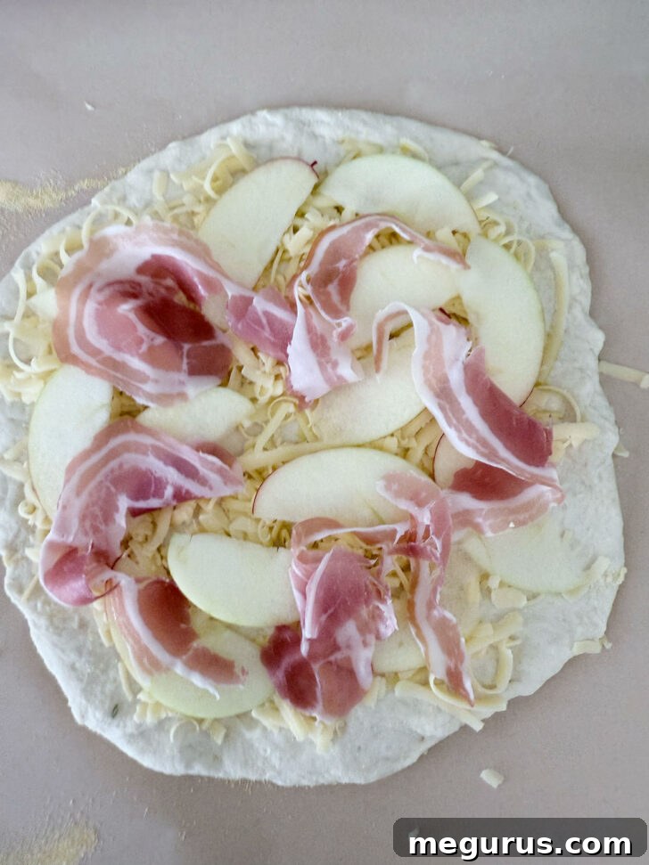 Pancetta torn and scattered over the top of the pizza.