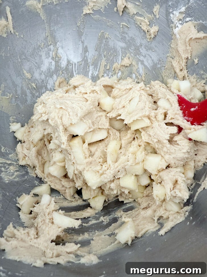 Adding the diced apple to the muffin batter.