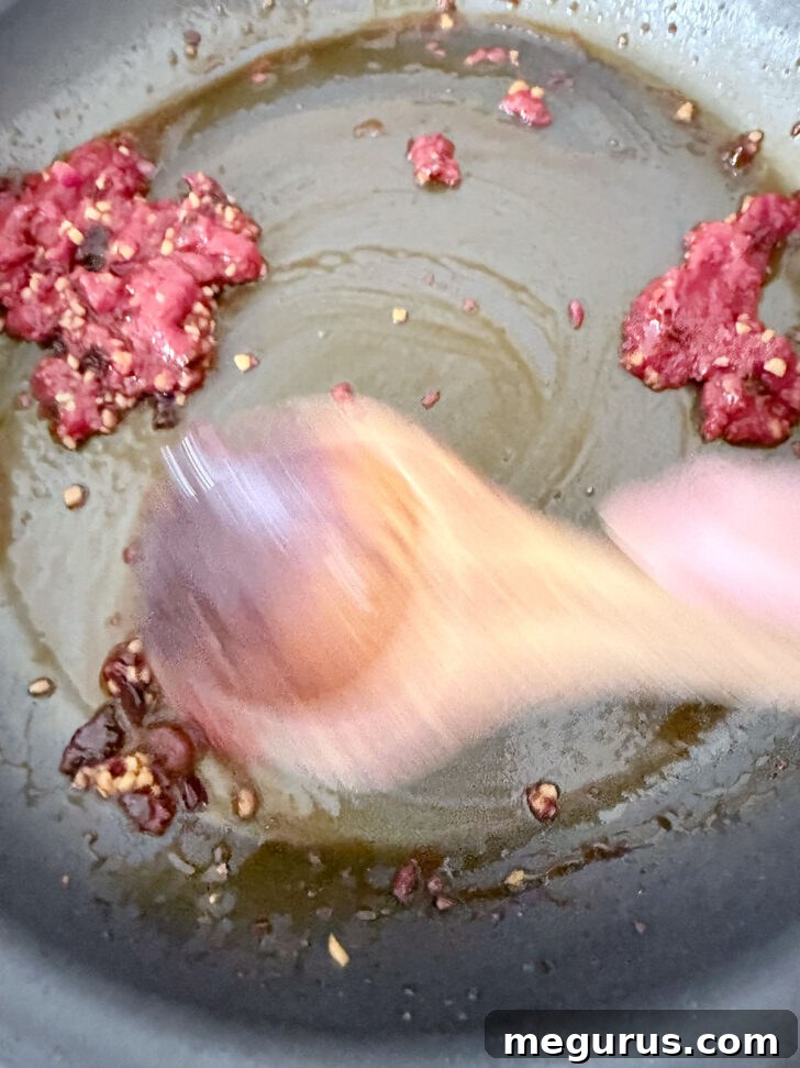 Cooking the tomato paste with the chili crisp and garlic.