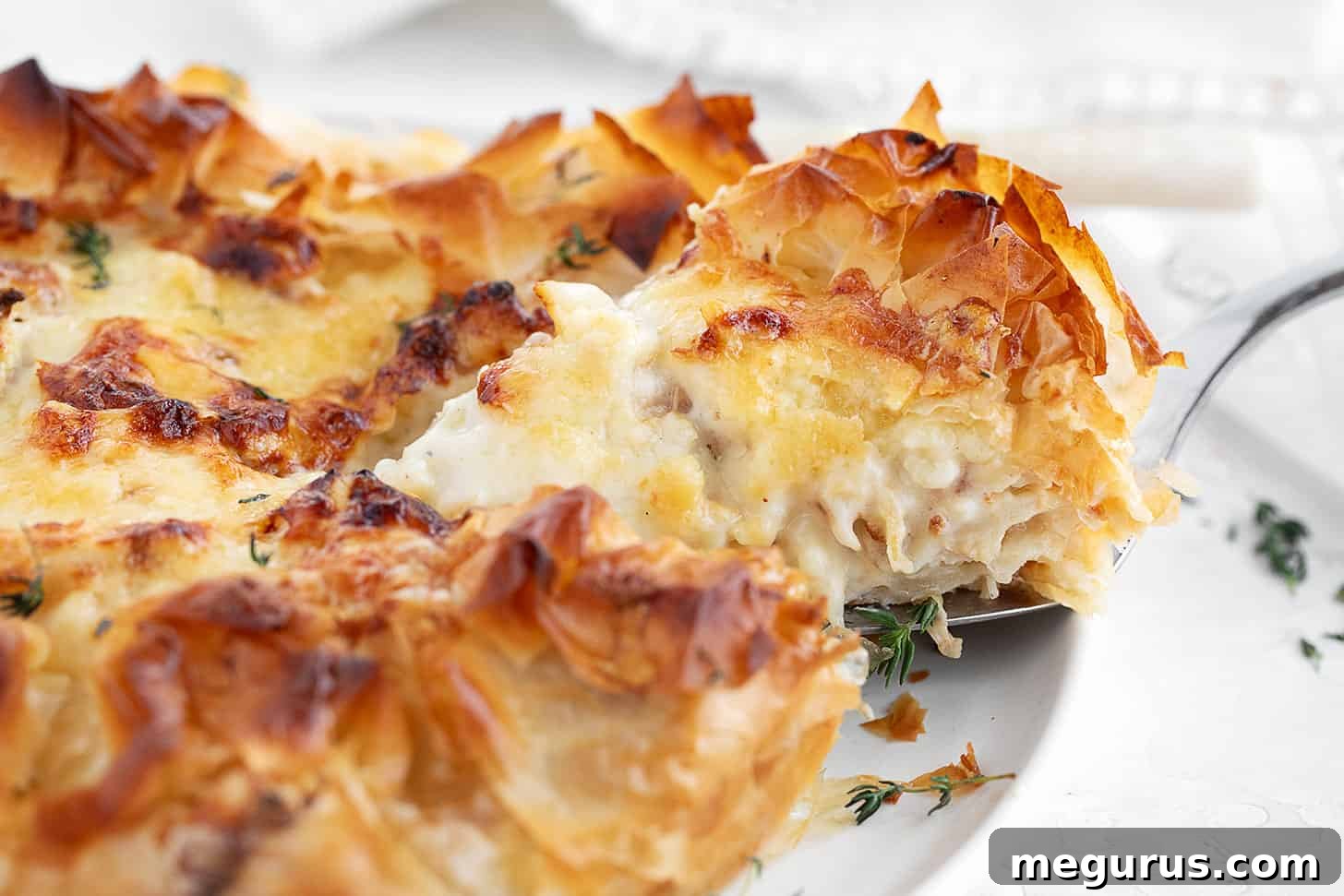 Sliced Cauliflower and Cheese Phyllo Pie ready to serve on a rustic plate.