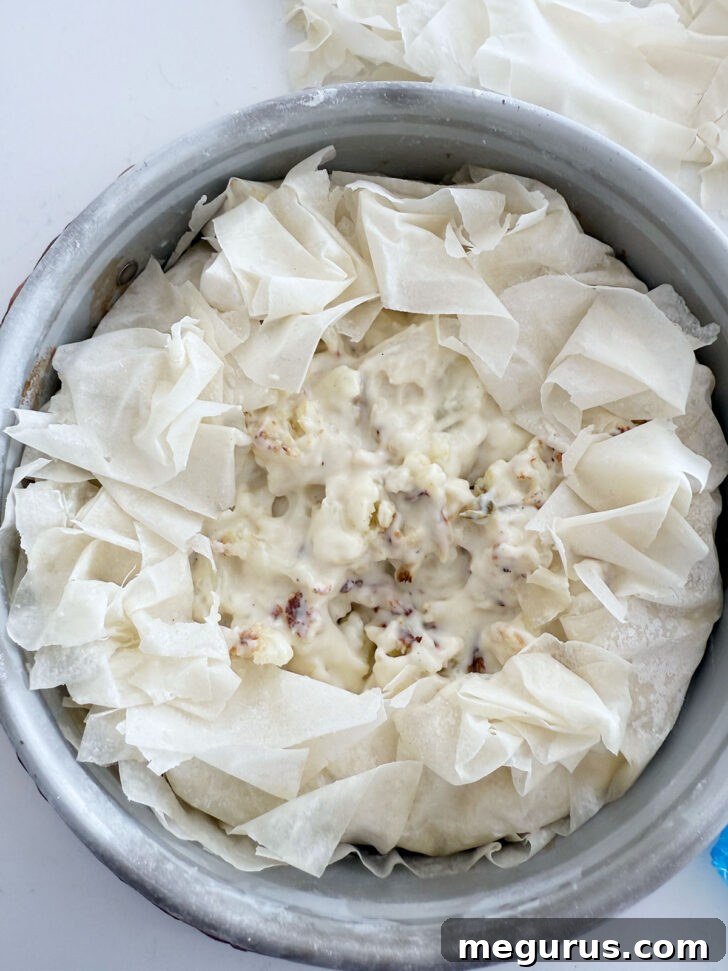 Excess phyllo pastry folded artistically over the top of the pie filling.