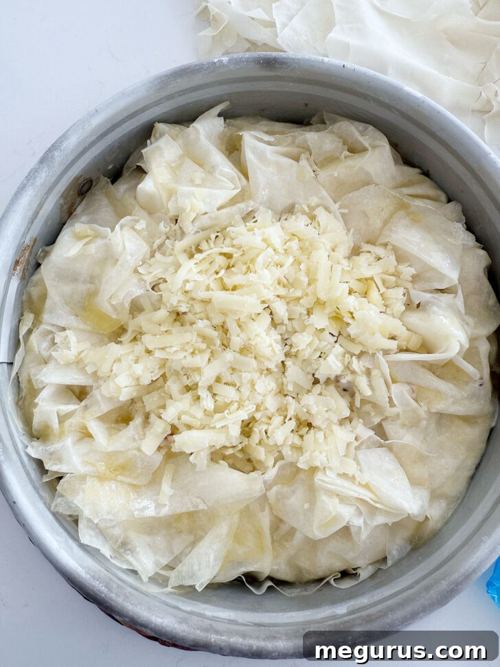 Extra shredded cheese scattered over the exposed center of the pie before baking.
