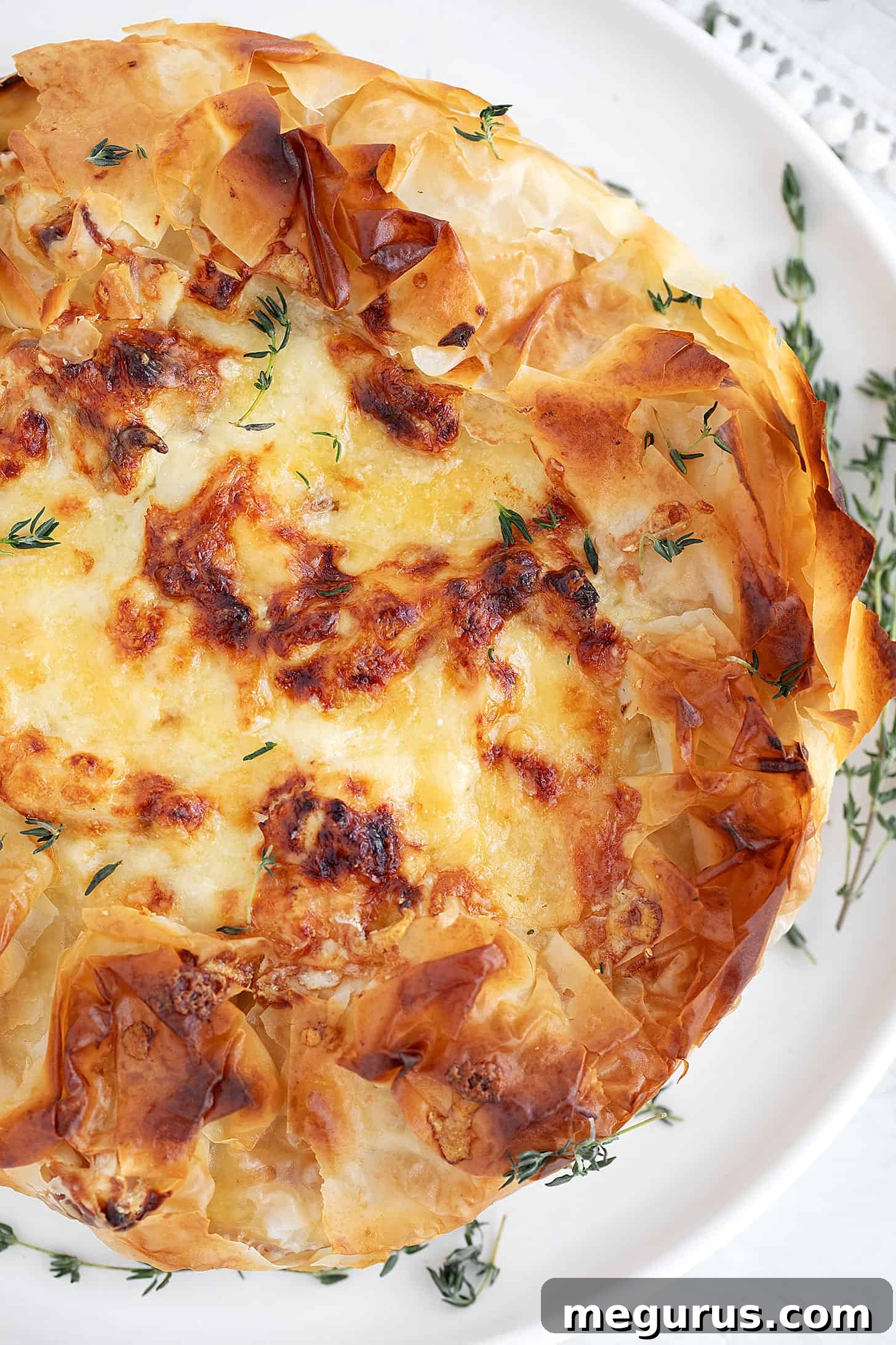 Baked Cauliflower and Cheese Phyllo Pie on a round serving plate, perfectly golden.