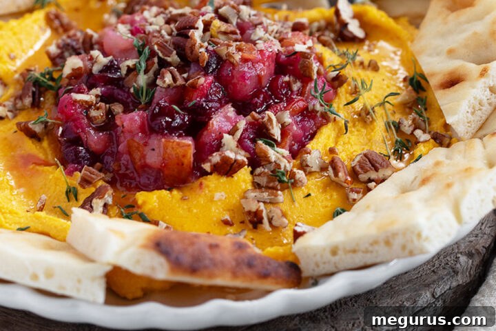 Butternut squash whipped feta on a serving plate, drizzled with honey and garnished.