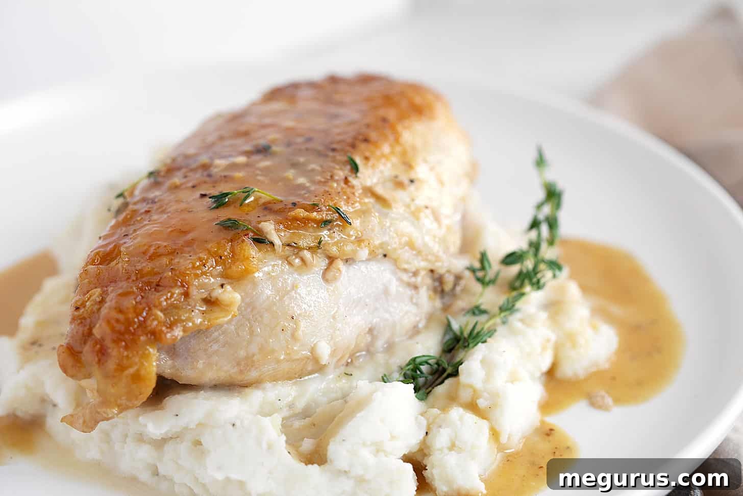 Perfectly cooked maple mustard chicken breasts served atop creamy mashed potatoes, ready to be enjoyed.