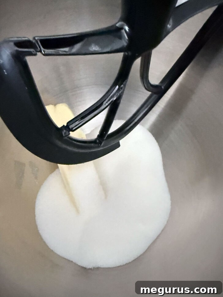 Butter and sugar are being creamed together in a mixing bowl, showcasing the light and fluffy texture.