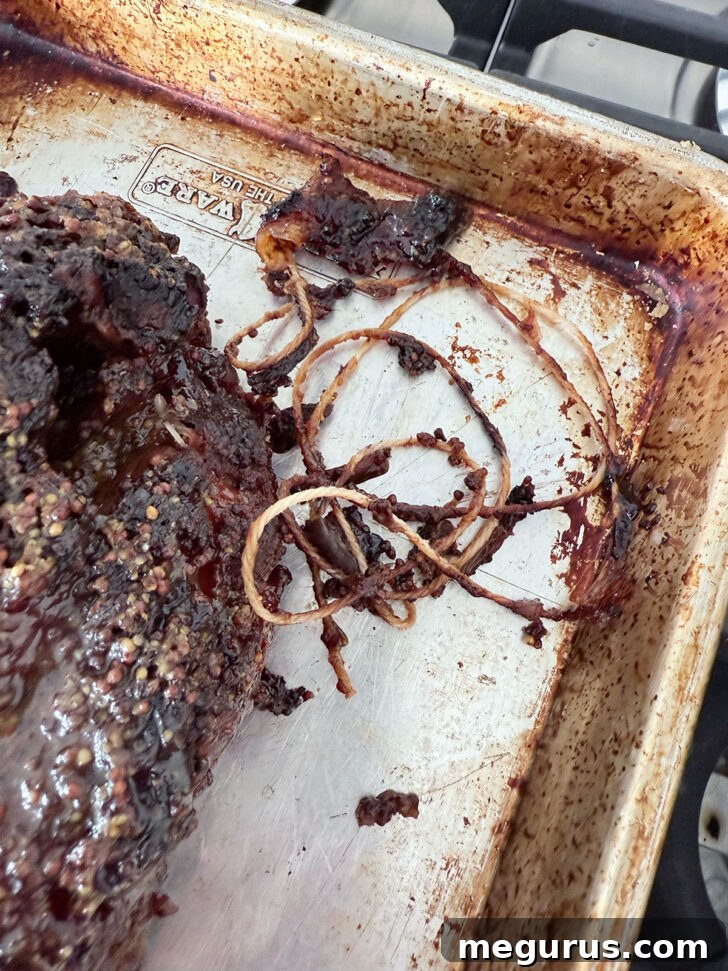 Butcher's string being removed from the perfectly roasted pork shoulder before shredding.