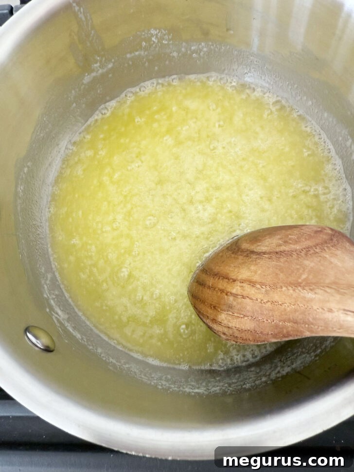 Butter melting in a saucepan, beginning to foam.