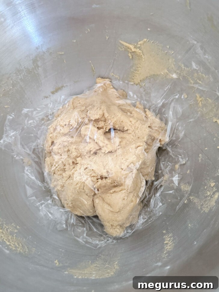 Finished cookie dough covered tightly with plastic wrap and placed in a bowl.