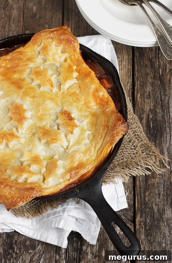 Close-up of a Skillet Beer-Braised Beef and Vegetable Pot Pie with a Golden Puff Pastry Topping