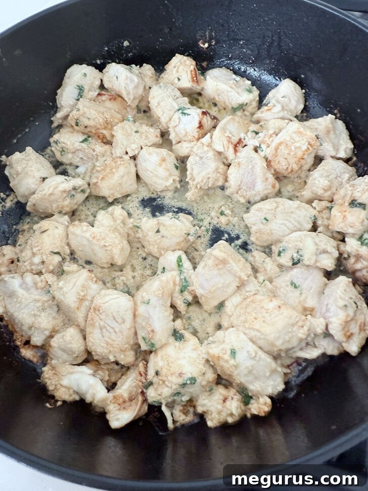 Marinated chicken cooking in a skillet.
