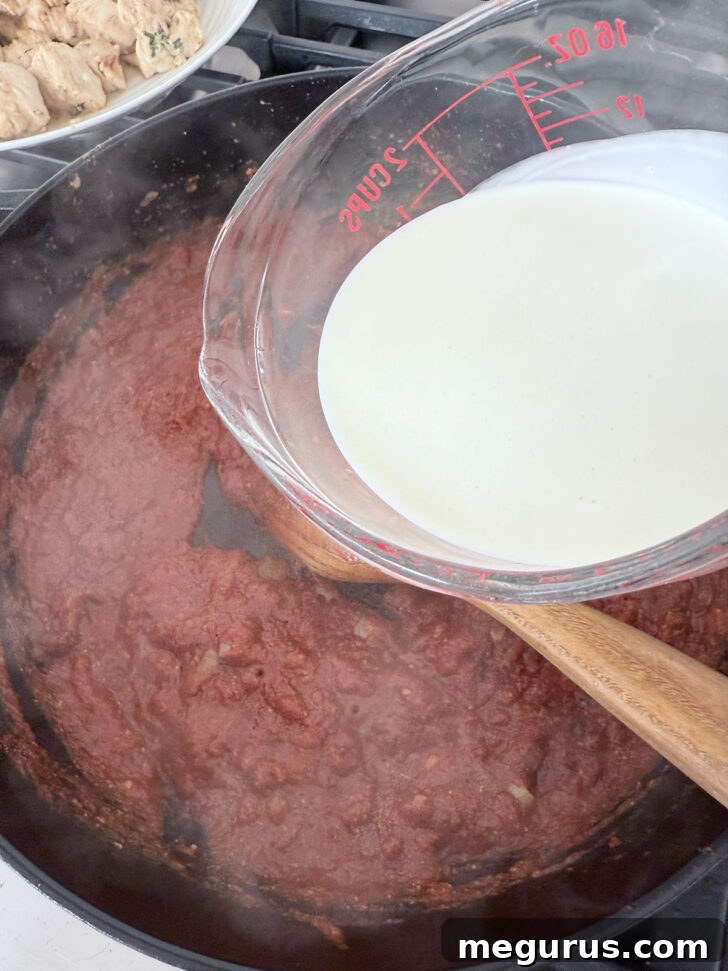 Adding the cream to the butter chicken.