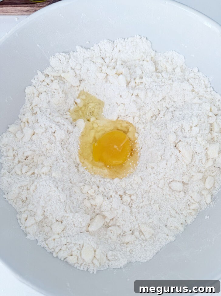 An egg being stirred into the crumb mixture to bind it.