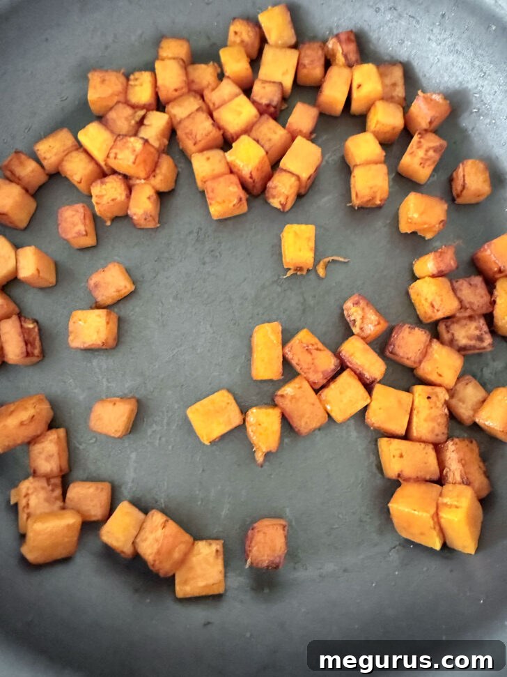 Diced butternut squash cooking in the same skillet.