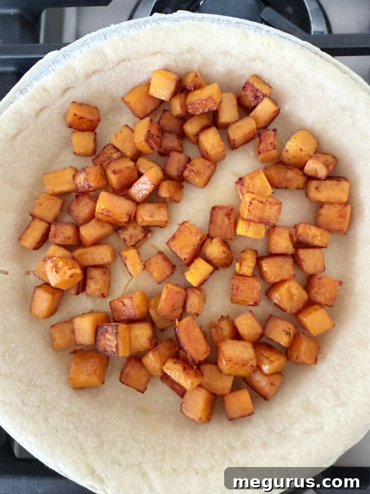 Cooked butternut squash added to the par-baked pie shell.