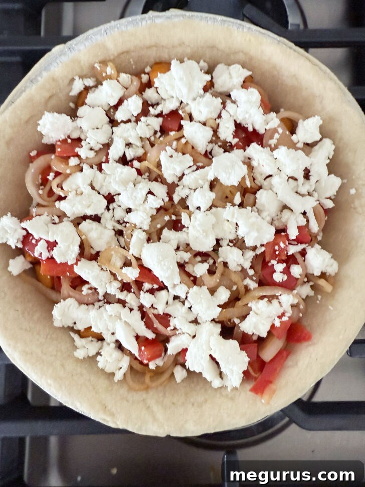 Shallots, bell pepper, and goat cheese added to the pie shell.