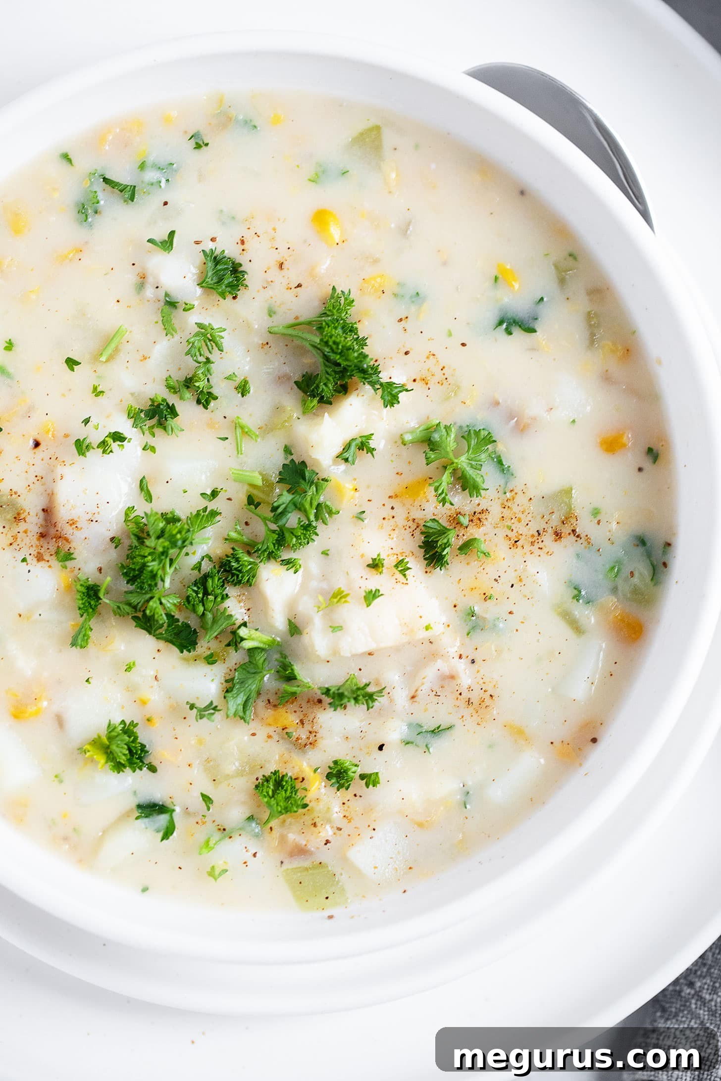 A large serving bowl filled with creamy cod chowder, ready to be dished out.