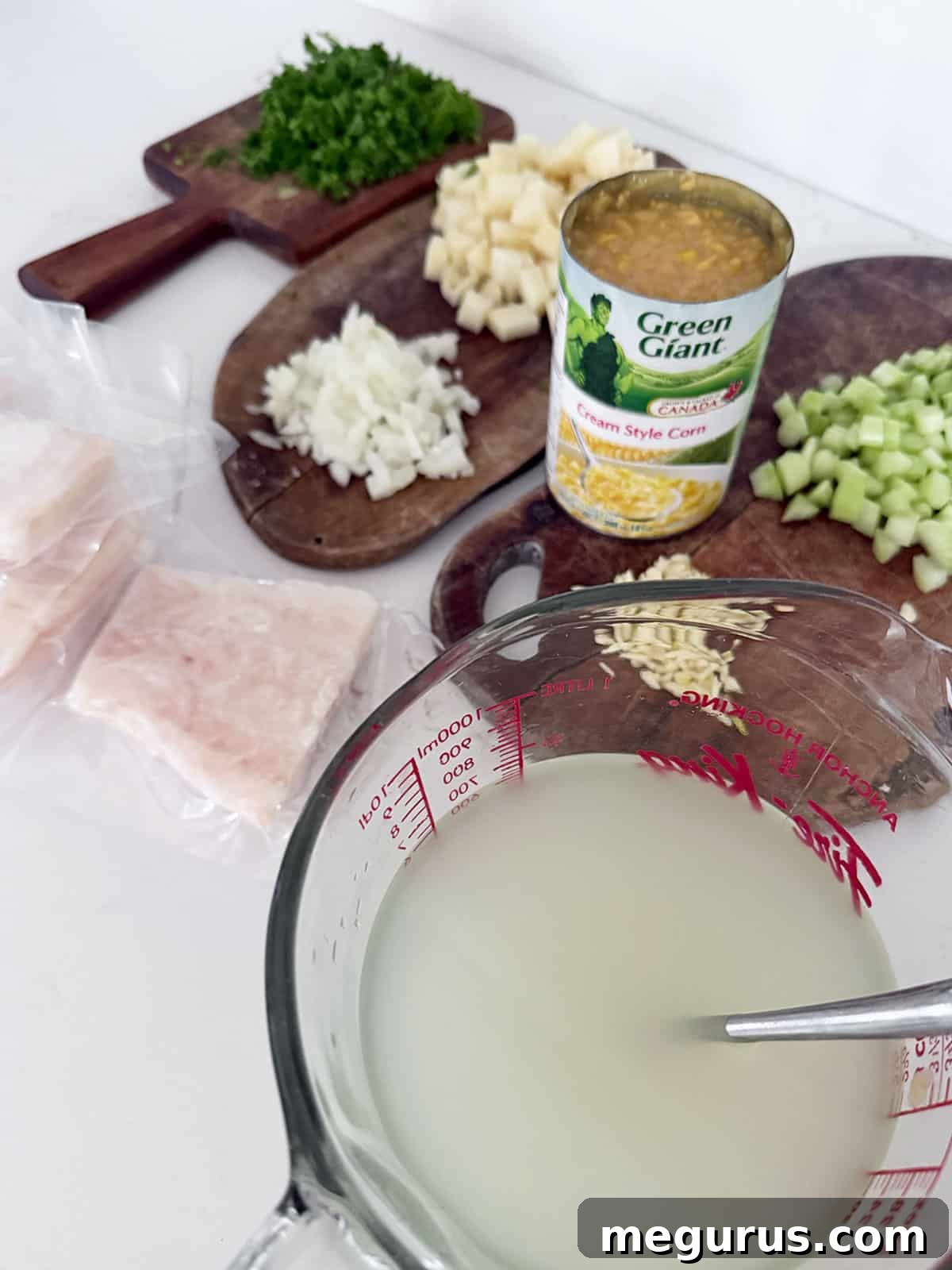 All the fresh ingredients for Cod Chowder laid out on a kitchen counter, ready for preparation.
