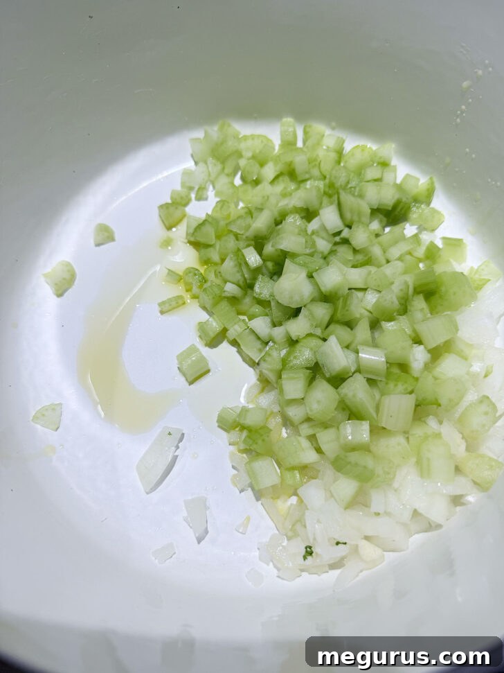 Sautéing diced onion and celery in a hot soup pot.