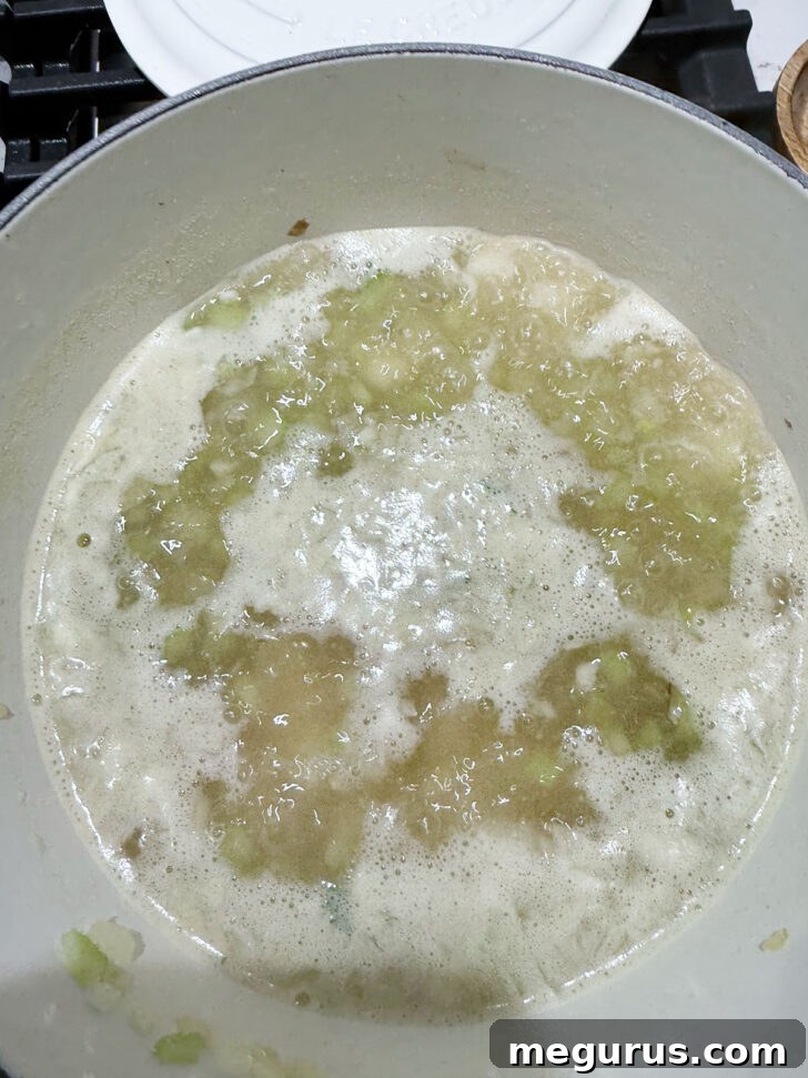 Diced potatoes simmering in a flavorful broth in a soup pot.