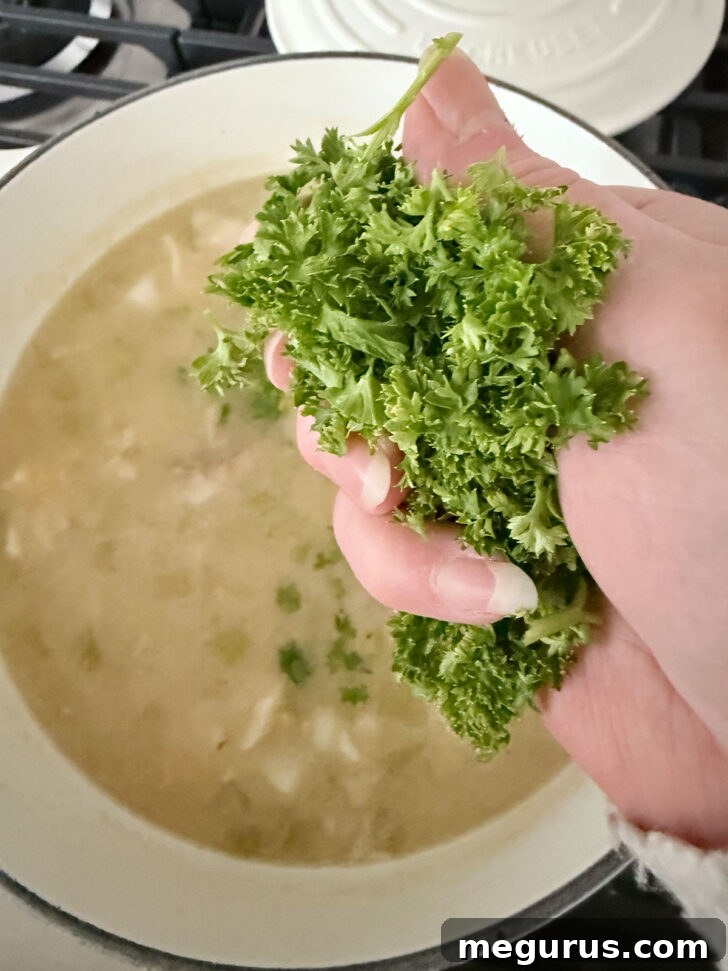 Adding chopped fresh parsley to the simmering chowder.