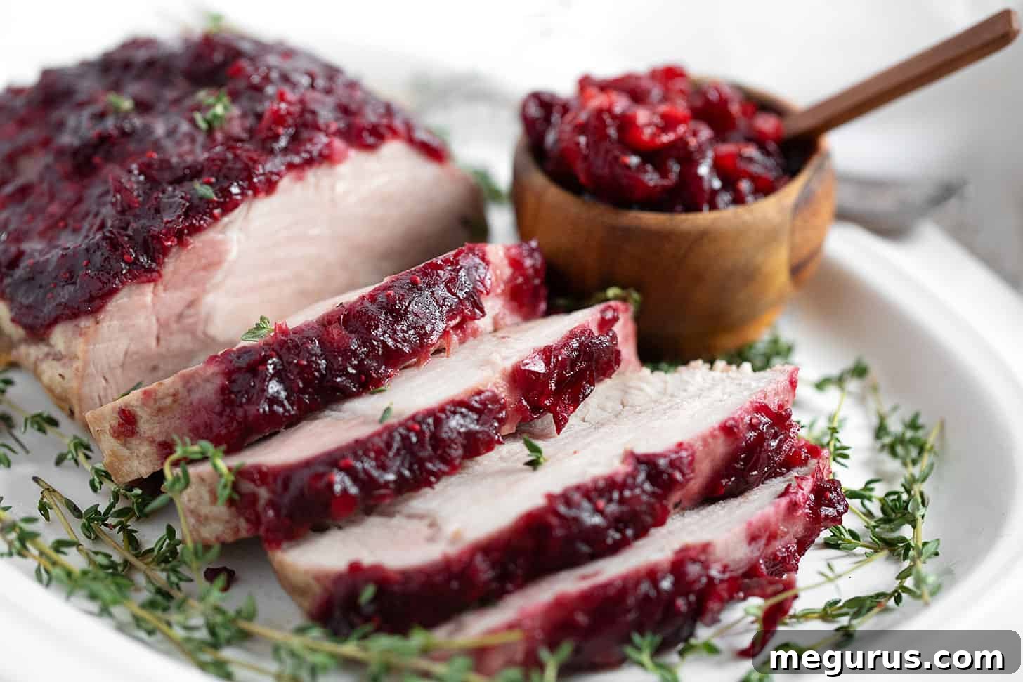 Boneless pork loin topped with a cranberry apple glaze, sliced and ready to serve.