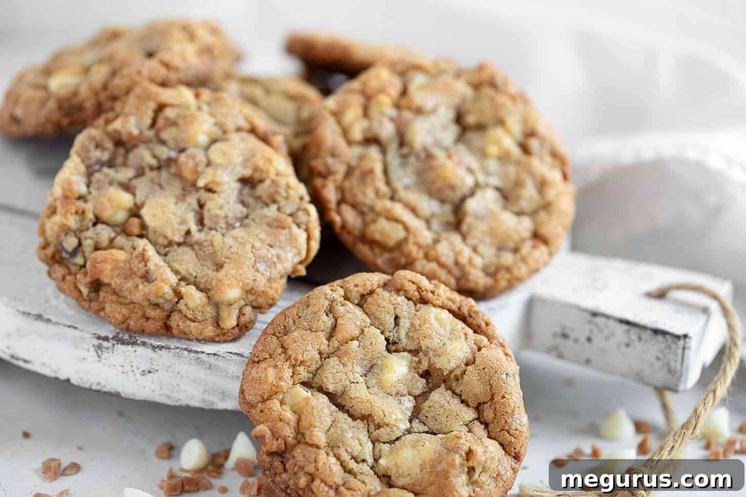 Exquisite Toffee, Walnut, and White Chocolate Cookies artfully arranged on a serving board, showcasing their golden-brown edges and generous inclusions.