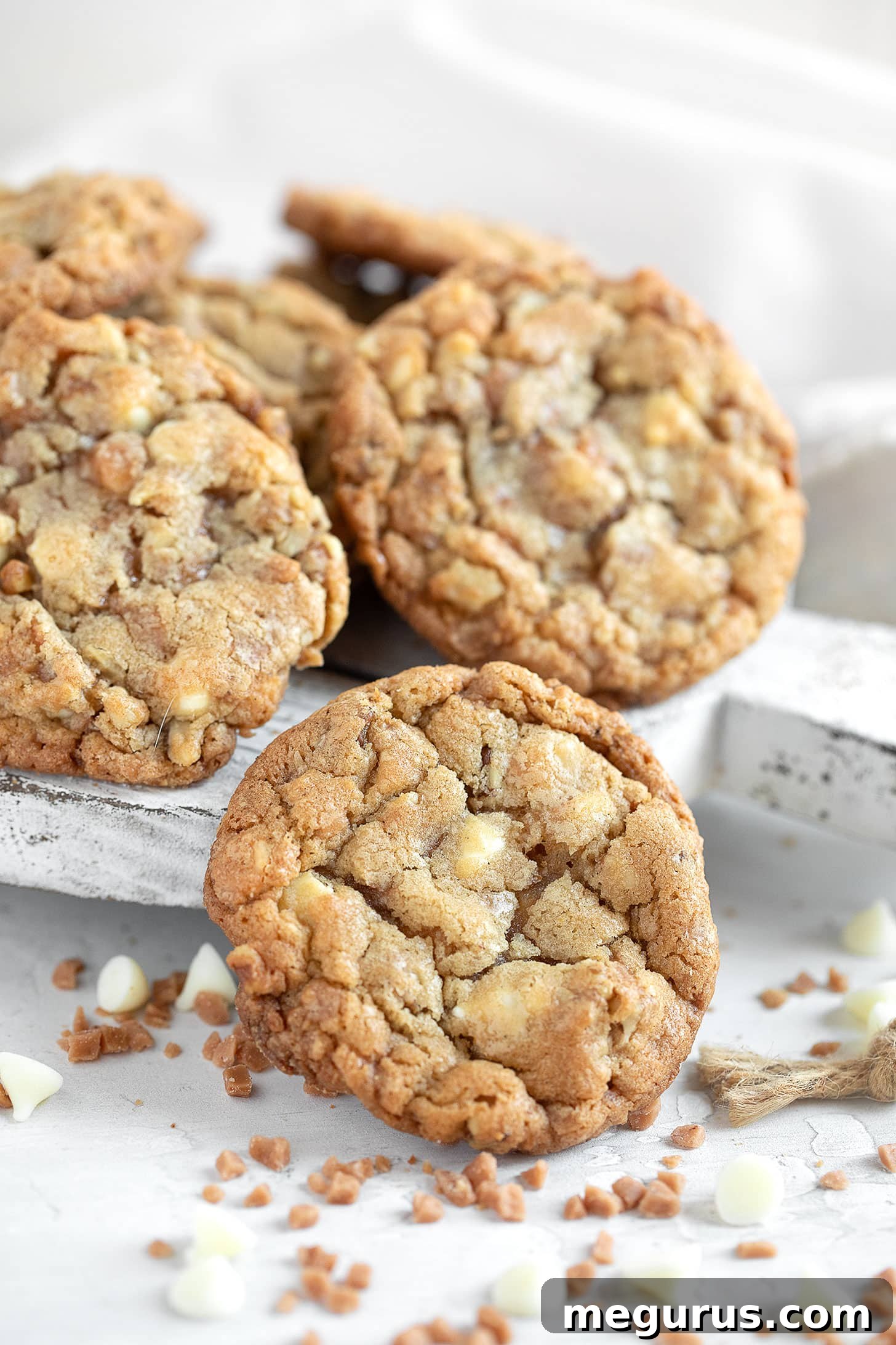 A stack of perfectly baked Toffee, Walnut, and White Chocolate Cookies, showcasing their rich texture and tempting ingredients.