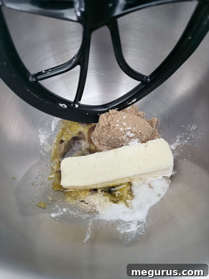 Room temperature butter and sugars being creamed together in a stand mixer bowl, turning light and fluffy.