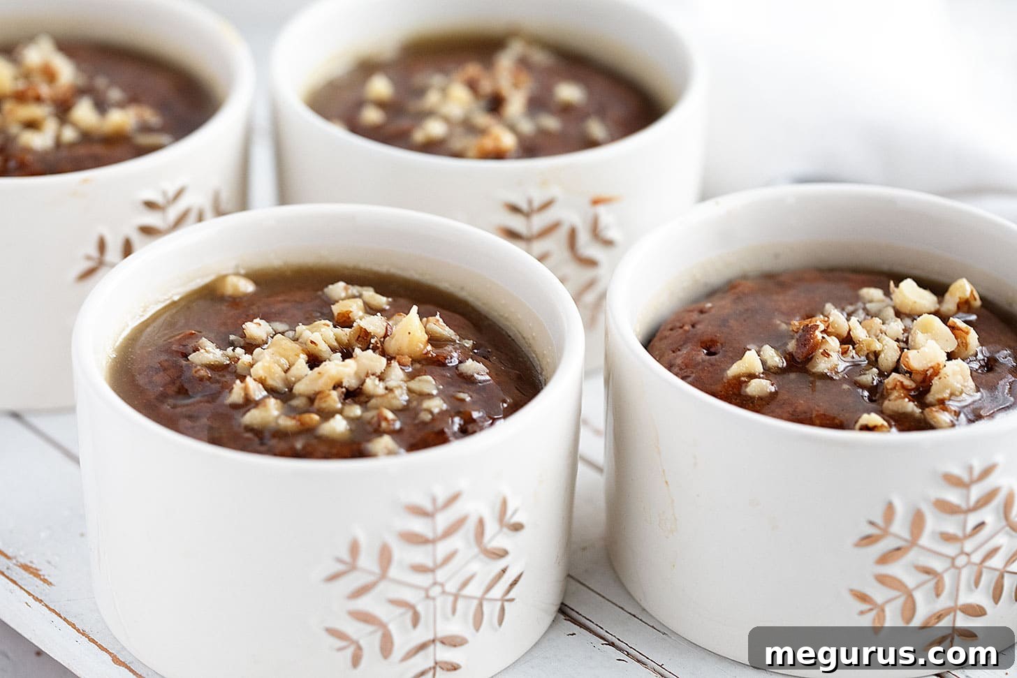Individual gingerbread sticky toffee puddings topped with a luscious toffee sauce, served in festive ramekins.