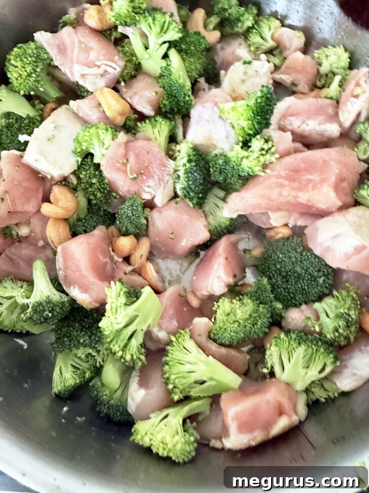 Cooking the broccoli, chicken pieces and cashews together.