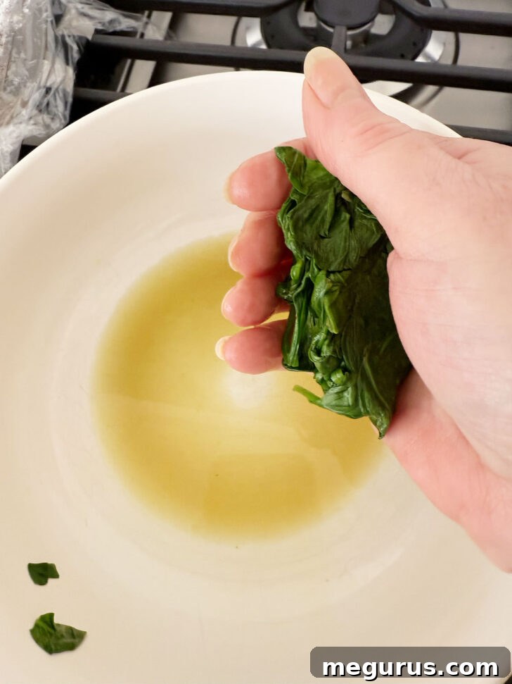 Squeezing excess water from cooked spinach.