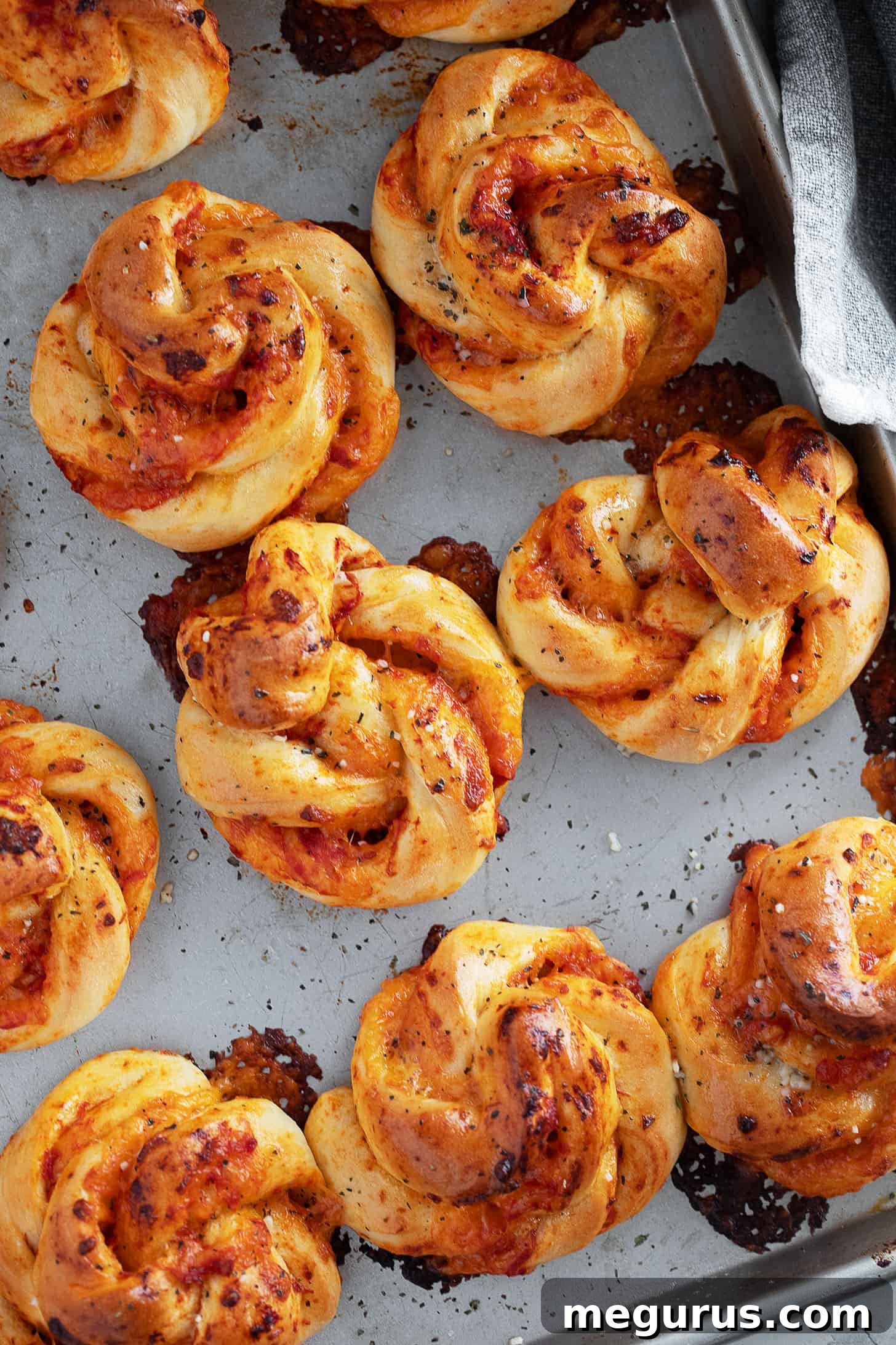 A batch of baked pizza twists on a baking sheet, perfectly golden and ready to serve.