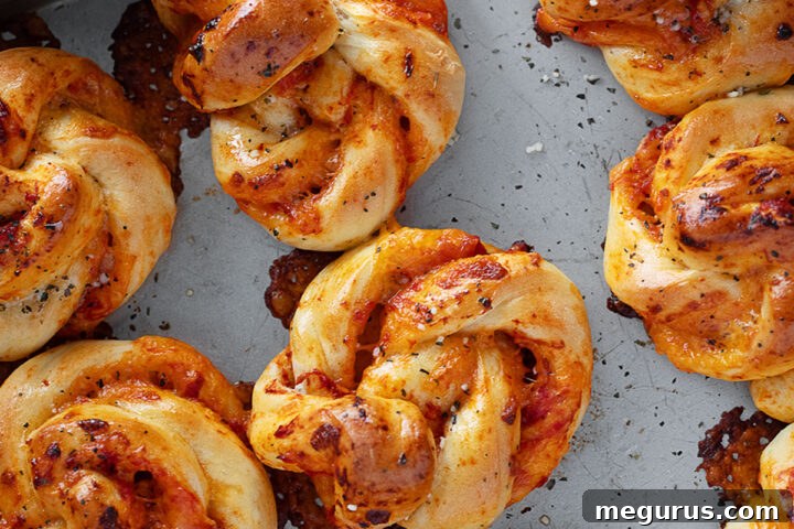 A freshly baked batch of Pizza Twists on a baking sheet.